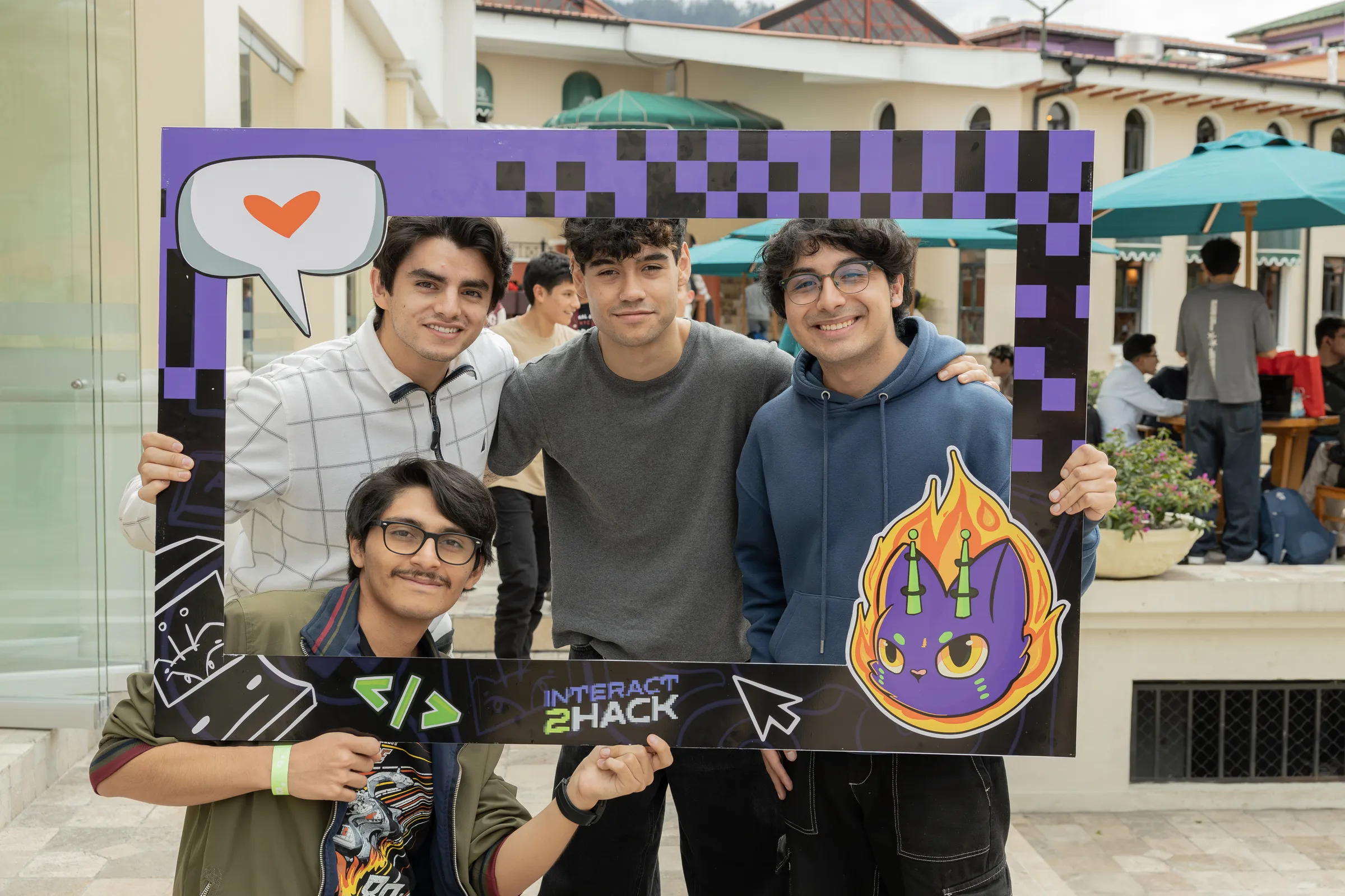 Sebastian and three teammates posing with an Interact2Hack photo frame