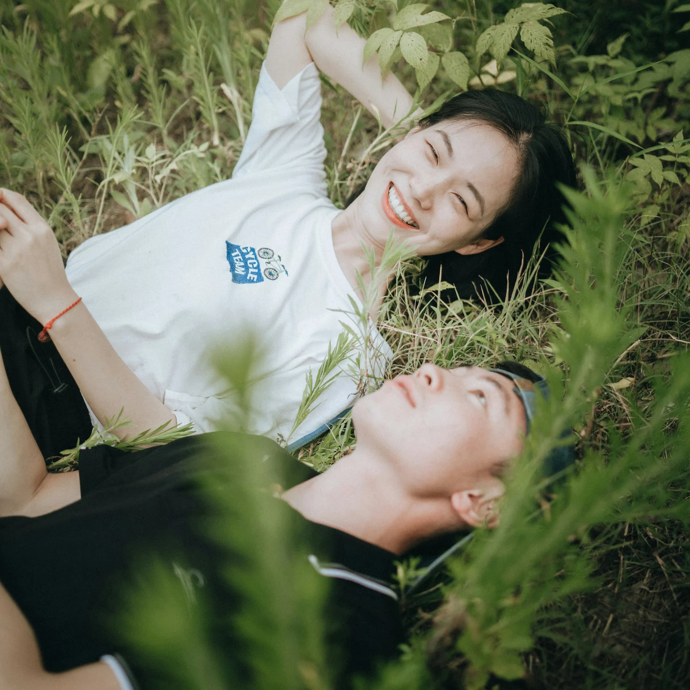 Two friends lying in the grass laughing, the life mino is designed to protect