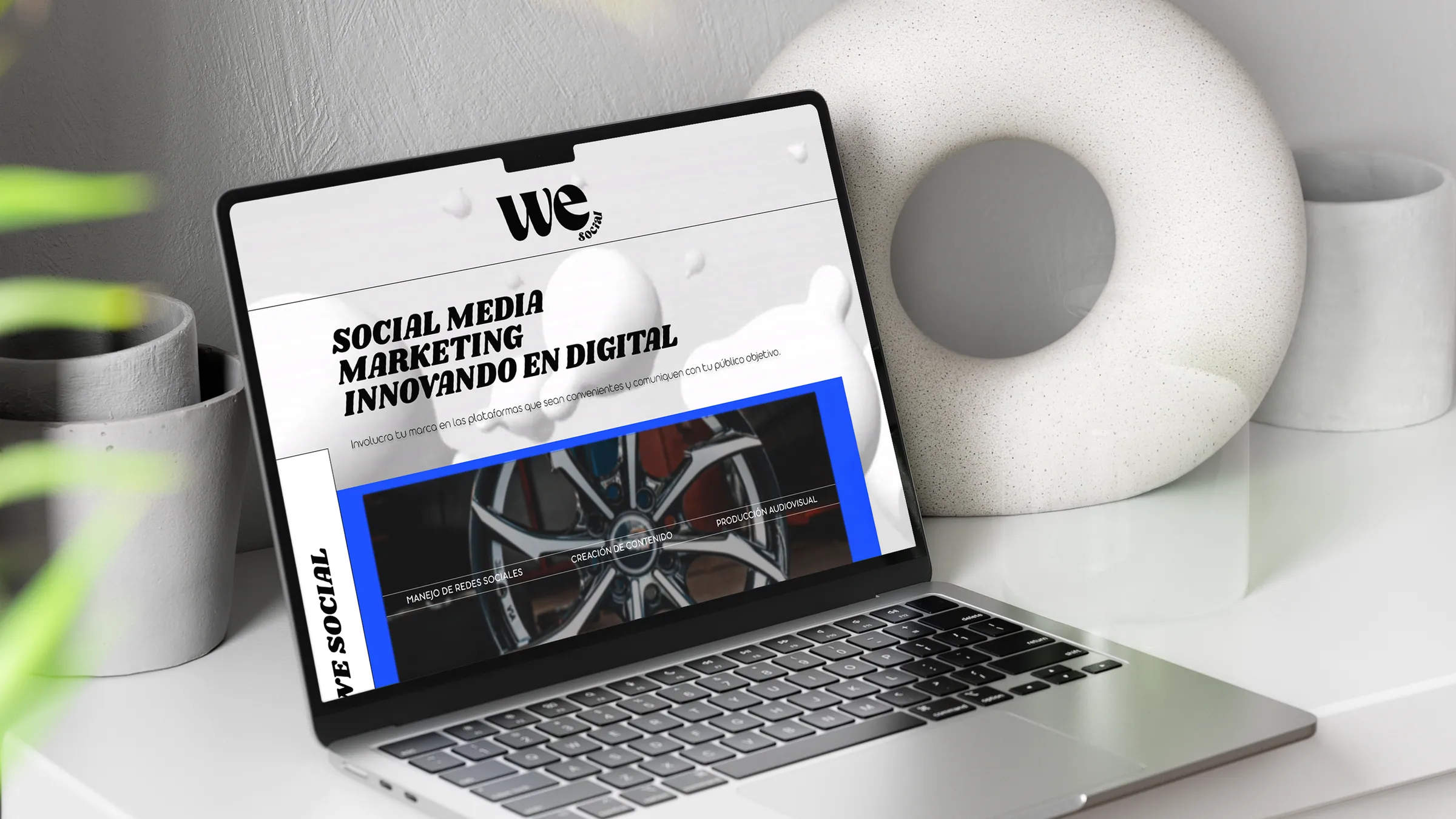 The We Social homepage running full-width on a laptop