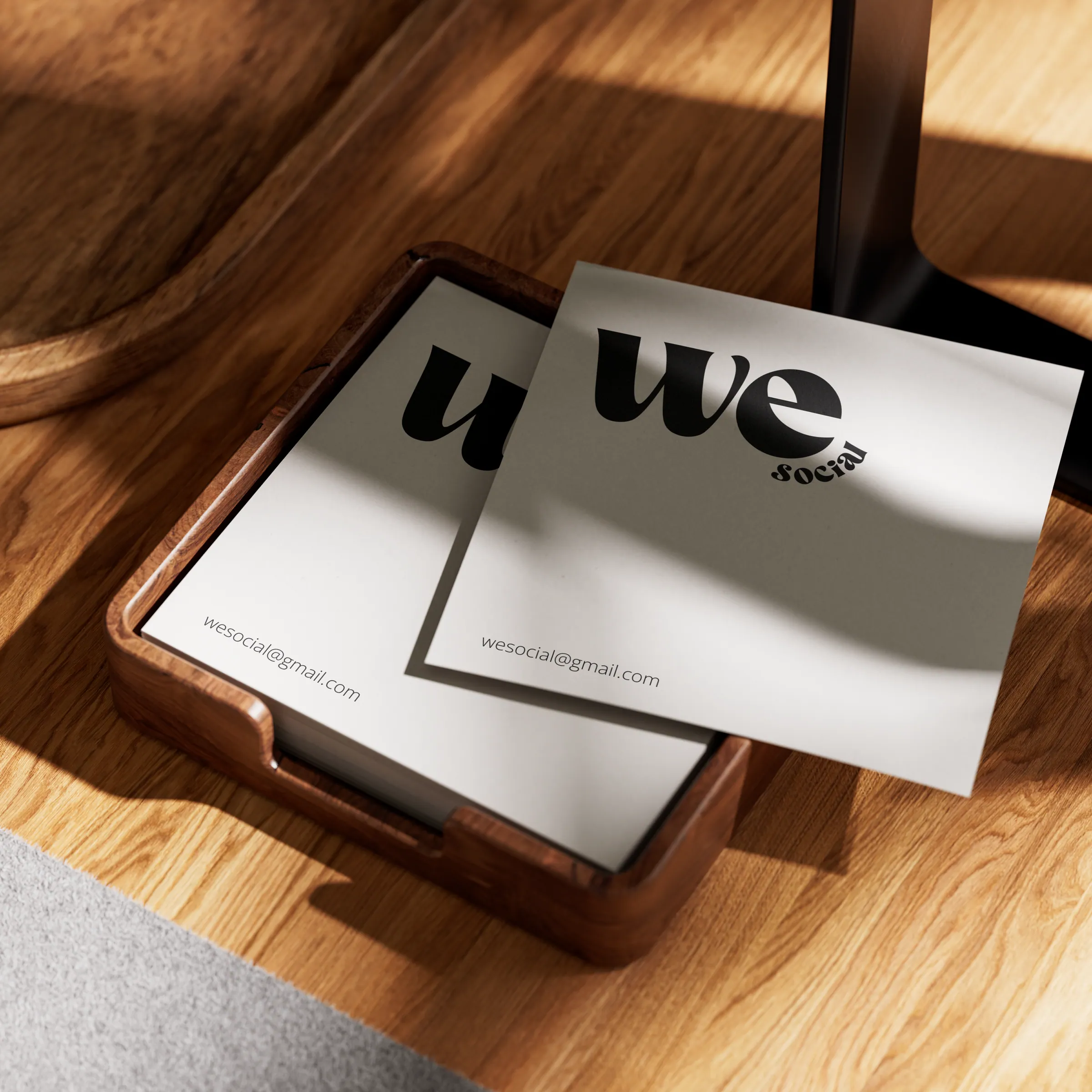 We Social letterhead resting in a wooden tray, the wordmark set above wesocial@gmail.com